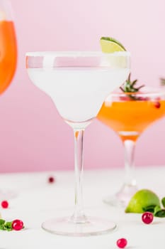 The rose exotic cocktails and fruits on table, against pink