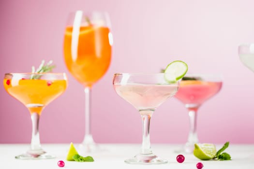 The rose exotic cocktails and fruits on table, against pink