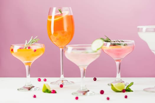 The rose exotic cocktails and fruits on table, against pink