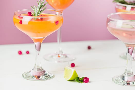 The rose exotic cocktails and fruits on table, against pink