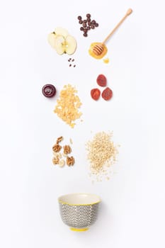 Falling granola with falling blueberries and honey flows from dipper. Healthy breakfast ingredients. Flying food