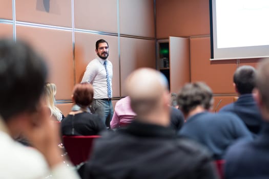 Relaxed Businessman Giving a Talk at Informal Business Meeting. Audience in the conference hall. Business and Entrepreneurship concept.
