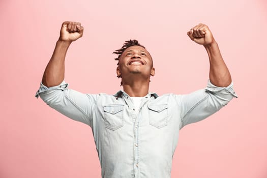I won. Winning success happy man celebrating being a winner. Dynamic image of afro-american male model on pink studio background. Victory, delight concept. Human facial emotions concept. Trendy colors