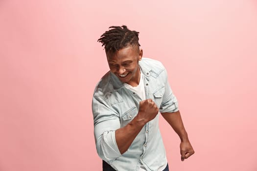 I won. Winning success happy man celebrating being a winner. Dynamic image of afro-american male model on pink studio background. Victory, delight concept. Human facial emotions concept. Trendy colors