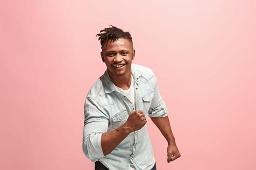 I won. Winning success happy man celebrating being a winner. Dynamic image of afro-american male model on pink studio background. Victory, delight concept. Human facial emotions concept. Trendy colors