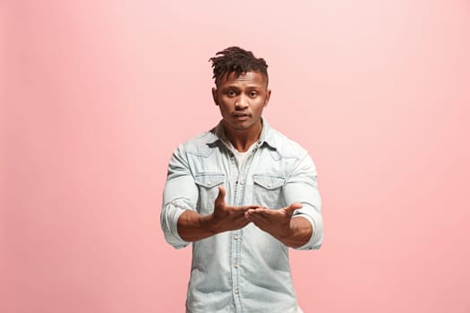 Argue, arguing concept. Beautiful afro male half-length portrait isolated on pink studio backgroud. Young emotional surprised man looking at camera. Human emotions, facial expression concept. Front view