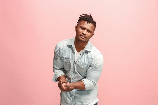 Pain concept. Beautiful male portrait isolated on pink backgroud. Young emotional surprised man looking at camera.Human emotions, facial expression concept. man overwhelmed with pain in hand