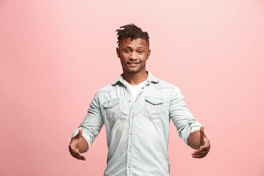 Happy business man standing and smiling isolated on pink studio background. Afro-american male half-length portrait. Young emotional man. The human emotions, facial expression concept. Front view.