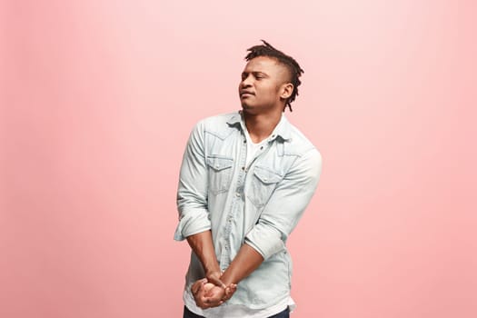 Pain concept. Beautiful male portrait isolated on pink backgroud. Young emotional surprised man looking at camera.Human emotions, facial expression concept. man overwhelmed with pain in hand