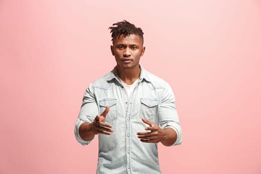 Argue, arguing concept. Beautiful afro male half-length portrait isolated on pink studio backgroud. Young emotional surprised man looking at camera. Human emotions, facial expression concept. Front view