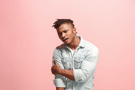 Pain concept. Beautiful afro male portrait isolated on pink backgroud. Young emotional surprised man looking at camera.Human emotions, facial expression concept. man overwhelmed with pain in shoulder
