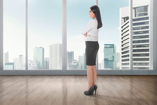 Side view of asian business woman standing on office room with cityscape background