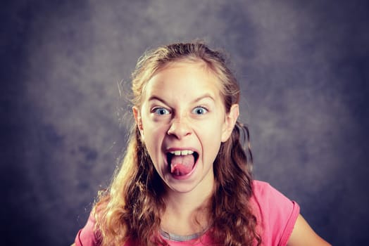 girl with blond hair and pink shirt making grimace
