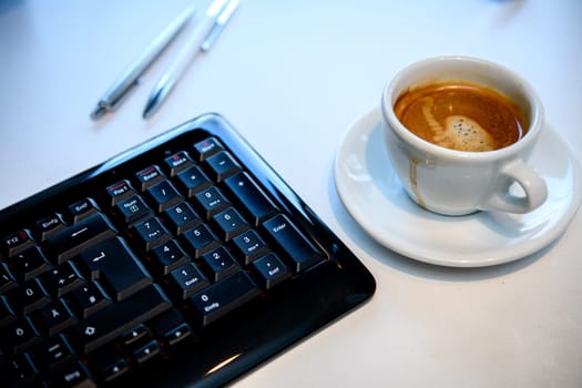 cup with coffee on tesk with computer keyboard
