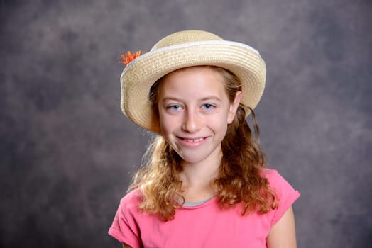 nice girl with blond hair in pink shirt and straw hat