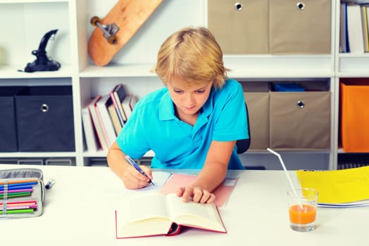 blond boy doing homework in his room