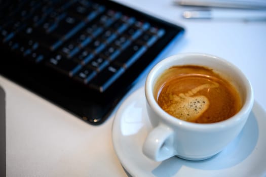 cup with coffee on tesk with computer keyboard