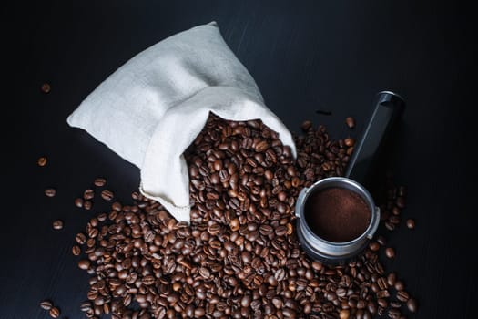 Coffee beans and holder from an espresso machine on kitchen table.