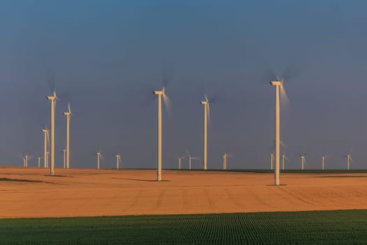 wind power turbines on a hill in sunrise. Dobrogea, Romania