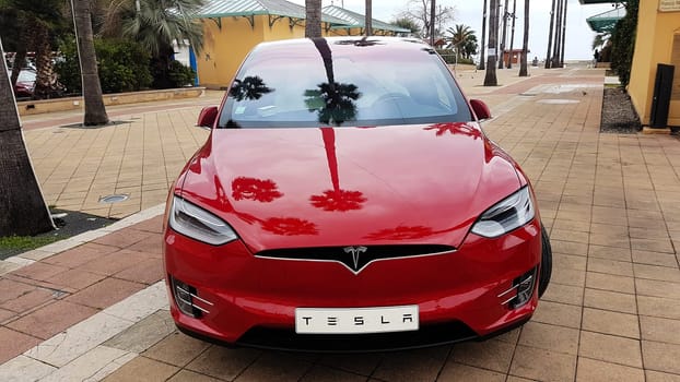 Menton, France - March 3, 2018: Red Tesla Model X Electric Car Parked on a Square in Menton on The French Riviera. Tesla Model X is a Luxury Full-Sized SUV, All-Electric Crossover