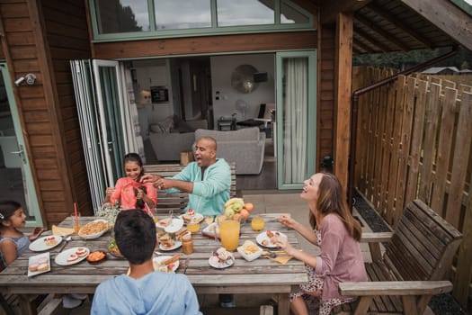 Family laughing and having fun during their brunch on vacation.