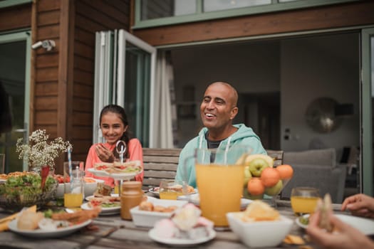 Father and daughter laughing at table during breakfast at a holiday lodge.