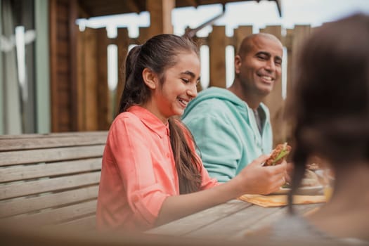 Young mixed race girl laughing at the table during brunch.