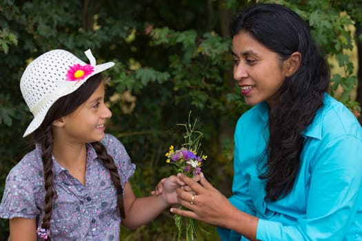 Girl gives mother a self-puffed bouquet of flowers