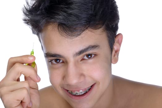 Cute teenager with white background, wearing braces on his teeth. Use a small toothbrush.