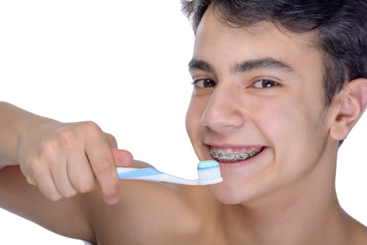 Cute teenager with white background, wearing braces on his teeth. Use toothbrush and toothbrush for cleaning.