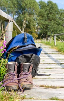 Hiking time - hiking boots and backpack on a path
