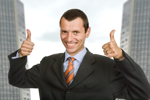 Young happy business man showing thumbs up