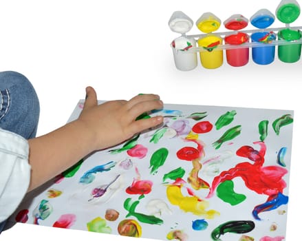 Kid paints with her fingers with different color paint