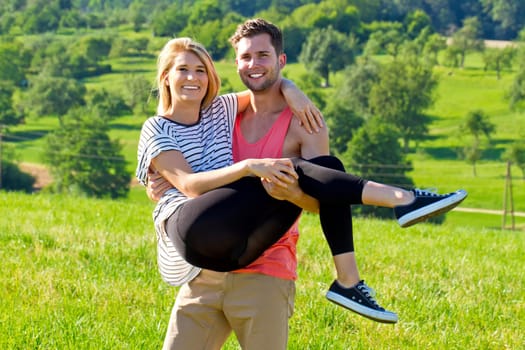 Young man carries his girlfriend