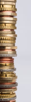 tower of many euro coins in grey background. Used coins