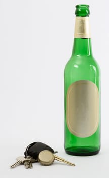 empty beer bottle with car key and crown cork isolated in grey background.