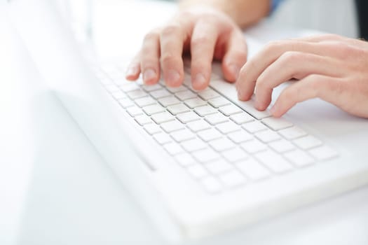 Fingers of man pressing laptop keys