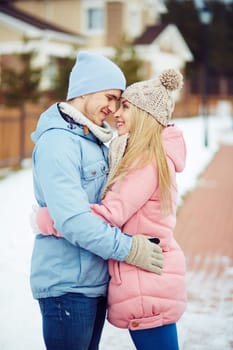Happy dates in embrace looking at one another outside