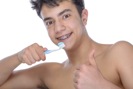 Cute teenager with white background, wearing braces on his teeth. Use toothbrush and toothbrush for cleaning.