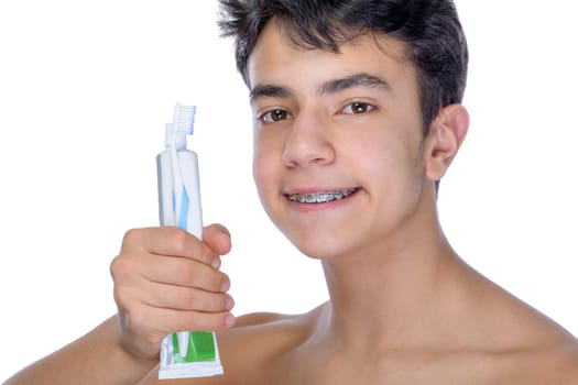 Cute teenager with white background, wearing braces on his teeth. Use toothbrush and toothbrush for cleaning.