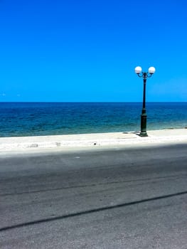 Road with lamp on the cost - Gouves, Crete, Greece