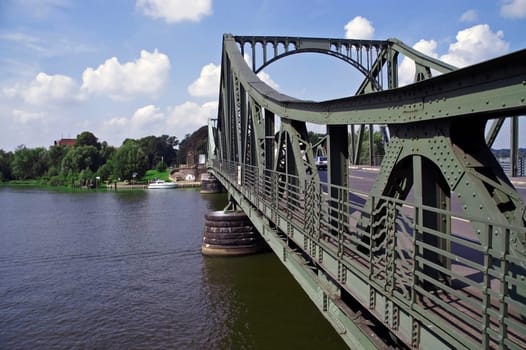 View of the Glienicke Bridge from east to west with blue skies with individual clouds.