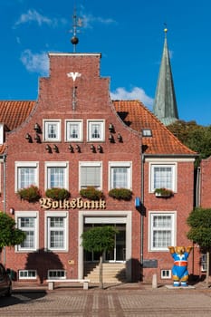 Esens,Germany - October 5,2016: House with brick façade with carillon,tower ball and wind vane on the market square in Esens.