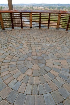 Garden Backyard circular brick stone pavers hardscape patio with wood railings stone wall view deck