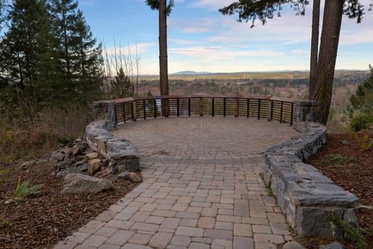Garden Backyard circular brick stone pavers hardscape patio with wood railings stone wall landscaping view deck