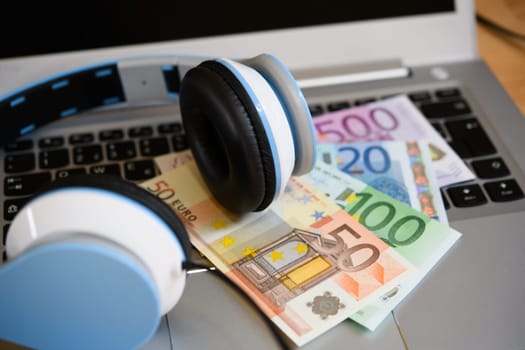 computer keyboard with headphones and euro bank notes