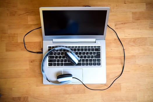 computer keyboard with headphones on wooden ground