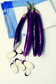 japanese eggplant on white board with kitchen towel