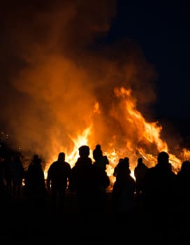silhouettes of people in frontof big easter fire