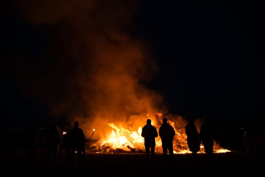 silhouettes of people in frontof big easter fire